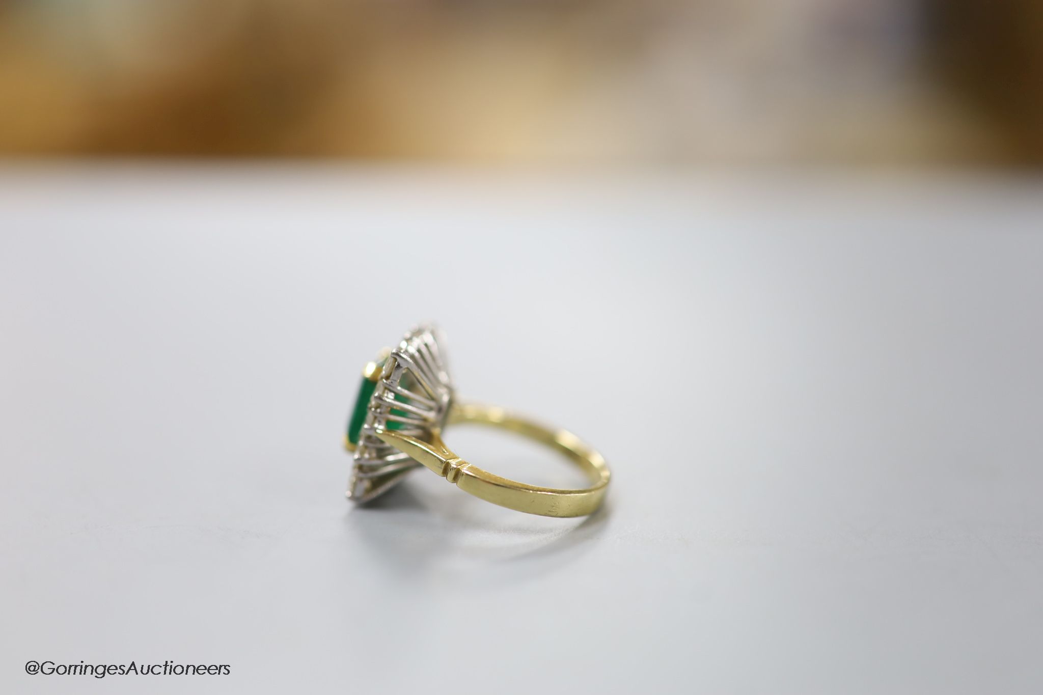 A modern 18ct gold, emerald and diamond set rectangular cluster ring, size K